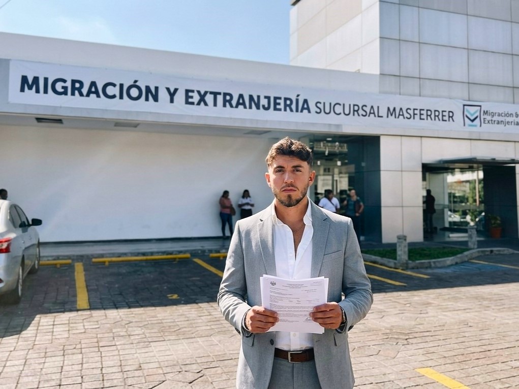 Advisor in a suit outside the Migración y Extranjería office in El Salvador